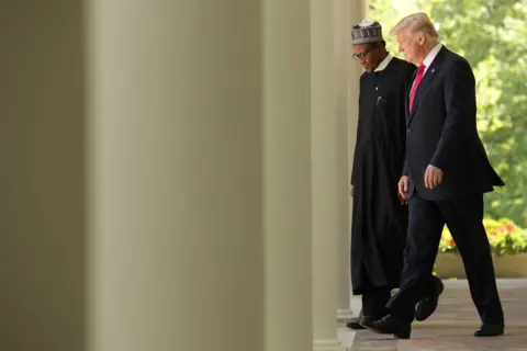 Getty Images Donald Trump and Muhammadu Buhari - both in formal dress - in discussions while walking past some columns at the White House. 