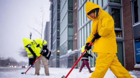 Workers cleaning up snow in Washington DC on 6 January. 