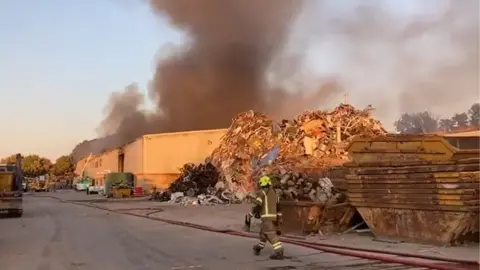 Matthew Cane Smoke coming from a large building on a recycling plant