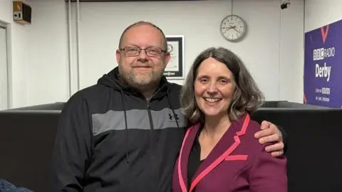 A man and a woman posing for a photo in the BBC Radio Derby studios