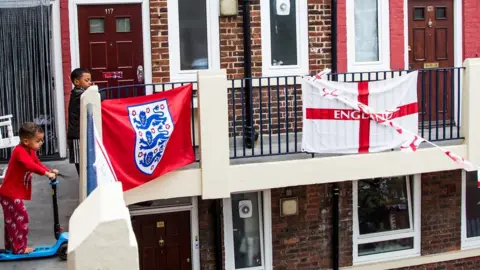 Getty Images Children outside flats adorned with England flags