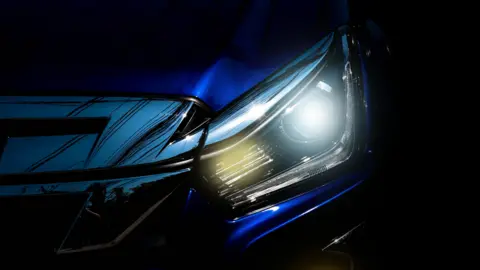 Getty Images Close-up of an LED headlight shining in the dark with a blue-white glow