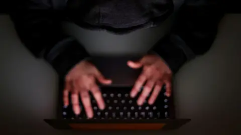 PA Media Overhead of someone typing on keyboard