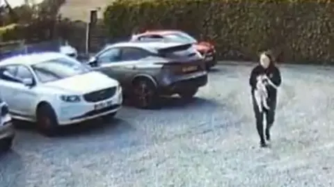 PA Media A CCTV still of a woman carrying Olaf through a car park.