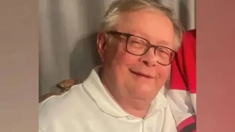 Family photograph Stuart Everett who has white hair, glasses and is smiling wearing a white polo shirt.