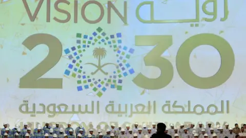 Reuters A large banner shows Saudi Vision for 2030