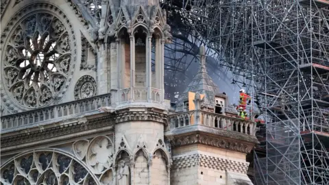 PA Firefighters stand on a balcony and observe damage from the fire