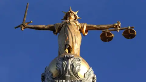 Statue of Justice stands on top of the Central Criminal Court building, Old Bailey, London