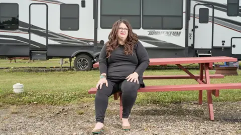 Ross Mantle/BBC Kristan Hawkins sits in front of her motor home