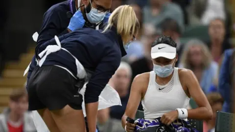 Reuters Emma Raducanu receives medical attention during her fourth round match at Wimbledon