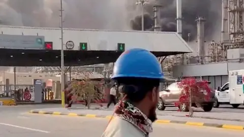 Workers evacuate area around Saudi Aramco's Ras Tanura oil refinery as smoke rises following a reported Iranian drone strike, in Ras Tanura, Saudi Arabia, on March 2, 2026