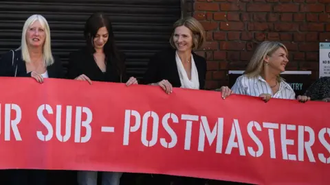 A group of sub-postmasters outside a court