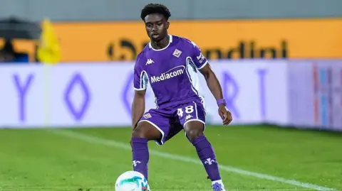 Tariq Lamptey in match action for Fiorentina wearing an all purple kit