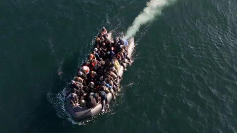 Migrants cross the English Channel in a small boat in March 2024