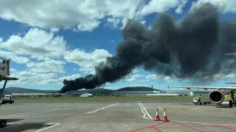 Black smoke in the distance, viewed from Belfast City Airport.