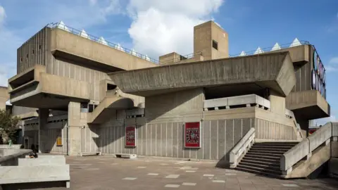 The brutalist building which is a mix of different shapes, stairs and corridors. 