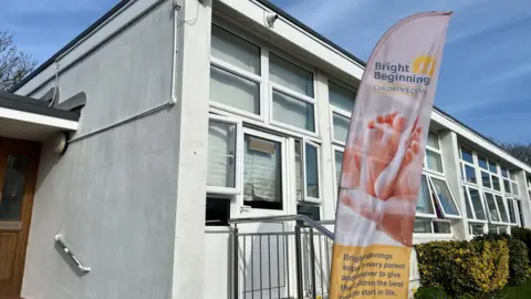 BBC The exterior of a children's centre building showing a one story building with lots of windows. 