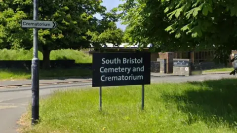 Google Image shows a sign for South Bristol Cemetery and Crematorium on grass beside a road. 
