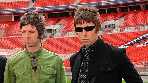 Getty Images Noel and Liam Gallagher at a football ground