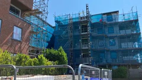 Un edificio está cubierto con una red azul.