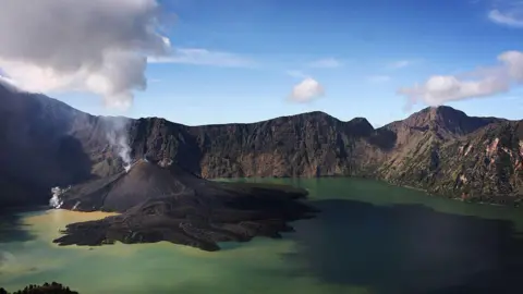 Ulet Ifansasti/Getty Images File image of Mount Rinjani and its surrounding lake; in this picture, the volcano was in an active erruption.