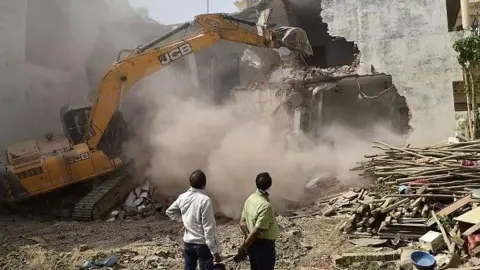 Getty Images A bulldozer is used to demolish the illegal structures at the residence of Javed Ahmed, a local leader allegedly involved in recent violent protests against Bharatiya Janata Party (BJP) former spokeswoman Nupur Sharma's inflammatory remarks about the Prophet Mohammed in Allahabad on June 12 2022. 