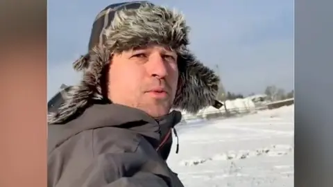 John Spence snowboarding in a Derry field.