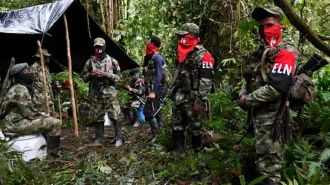 AFP via Getty Images ELN guerrillas stand at an improvised camp in the Choco jungle, Colombia, in 2019
