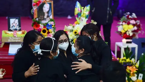 AFP Nurse Keyla Martinez's sister is hugged by family as she mourns by her coffin during her funeral in La Esperanza, Honduras, on February 9, 2021.