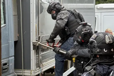 Firearms Officers breaking open a lorry housing a suspected cannabis plant nursery in St Leonards