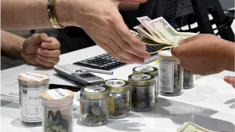 Getty Images The vast majority of legal cannabis purchases are made with cash due to a federal ban on the drug