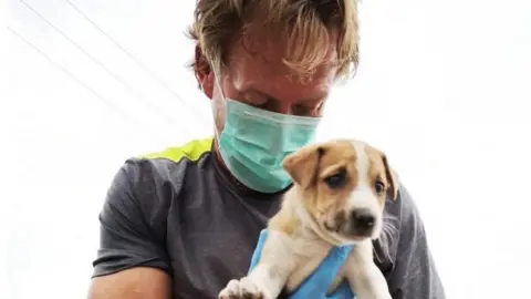 PA Media Pen Farthing holding a dog