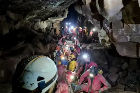 South and Mid Wales Cave Rescue Team Rescue team carrying injured caver on a stretcher through a cave, 8 November 2021