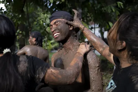 MADE NAGI / EPA-EFE Balinese people cover their bodies with mud