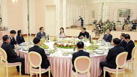 Getty Images In this handout image from the South Korean Presidential Blue House, Chung Eui-Yong, head of the presidential National Security Office talks with North Korean leader Kim Jong-Un (5th R) during a dinner in Pyongyang, North Korea on March 5, 2018.