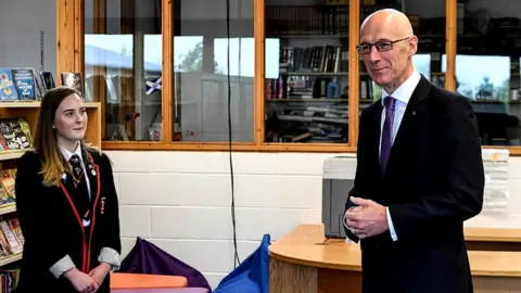 PA Media John Swinney and pupil