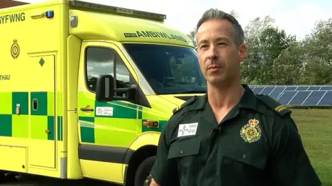 Lee Brooks in front of ambulance