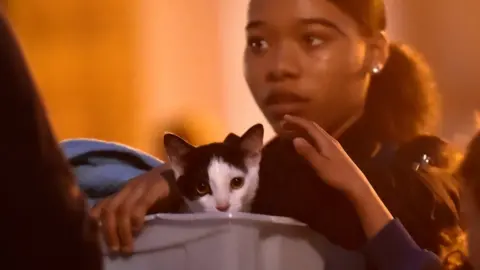 Reuters Woman carrying cat and possessions out of Taplow tower