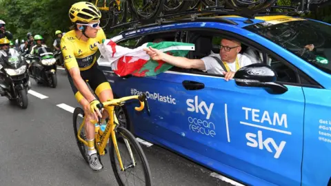 Getty Images Geraint Thomas accepting a Welsh flag from Sir David Brailsford