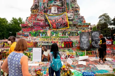 Getty Images Colourful graffiti now adorns the plinth supporting Robert E Lee's statue in Richmond
