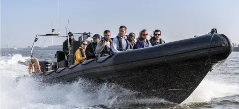 Channel 4 Hunted contestants on a speedboat heading for Liverpool docks