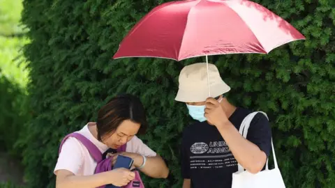Getty Images Tourists in Madrid shelter from the heat