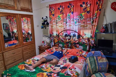 Natalia Favre Alexander in his room decorated with a Micky Mouse theme