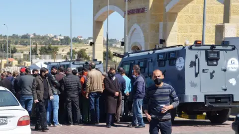 Reuters People gather outside the new Salt government hospital in Jordan, 13 March 2021