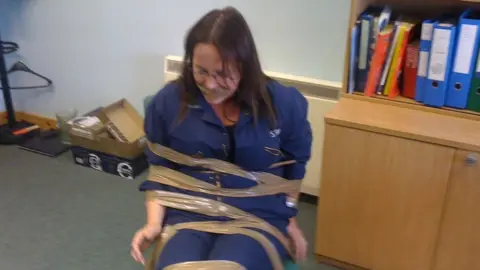 DeeAnn Fitzpatrick taped to a chair