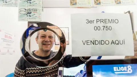 EPA Juan Carlos De Quintana, owner of the lottery administration number 1 in Vitoria celebrates selling the number 00750, awarded the third prize in "El Gordo".