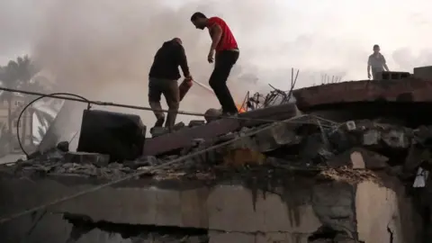 Getty Images Search and rescue efforts continue in destroyed house of Zaydan family hit by Israeli airstrike in Deir Al-Balah, Gaza on October 15, 2023.