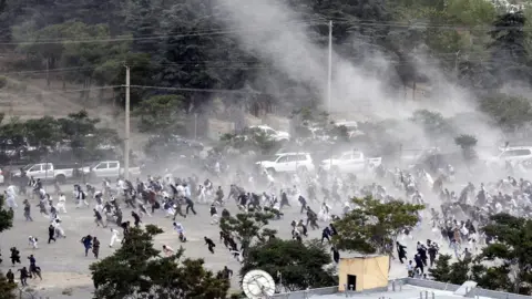 EPA People run after an explosion during the funeral of one of the victims of the violent protests in Kabul