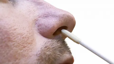 Science Photo Library A man having his nose swabbed