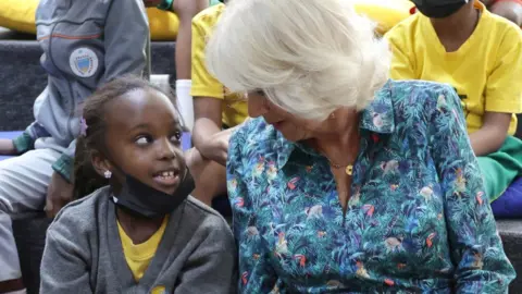 PA Media The Duchess of Cornwall meets a child during her visit to Rwanda